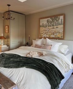 a large bed sitting in a bedroom next to a painting on the wall above it