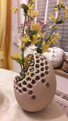 a vase with flowers in it sitting on a table next to a window sill