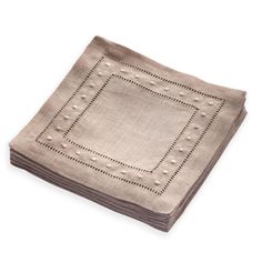 a linen napkin with an embroidered design on the front and sides, folded in two rows