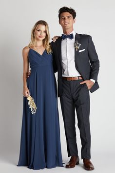 a man and woman in formal wear posing for the camera