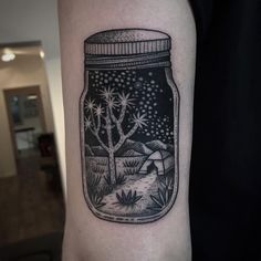 a jar filled with water sitting on top of a person's arm