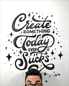 a man with glasses is standing in front of a sign that says create something today even if sucks