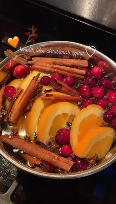 a pan filled with fruit and cinnamons on top of a stove