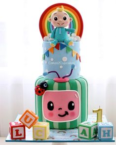 a three tiered cake decorated with an image of a baby sitting on top of it