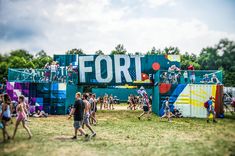 many people are walking around in the grass near a sign that says fort on it