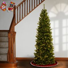 a small christmas tree in a room with stairs