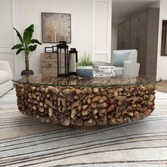 a living room filled with furniture and a large glass table covered in wood chips on top of a rug