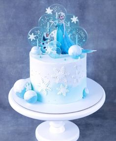 there is a cake with frosting and decorations on the top, along with snowflakes