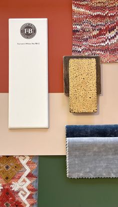 several different colored rugs are on display in front of an orange and red wall