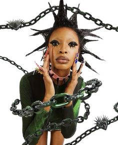 a woman with black hair and spikes on her head is surrounded by chain link chains