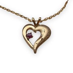 "Gorgeous, delicate vintage deadstock (unworn/  in original packaging) 14kt gold filled neckace. Features a small heart pendant with etched accents, and small, cut ruby at the center. Circa 1970's - Made in USA.  Would make the perfect gift for a valentine, July birthstone, or just because!  Measurements: Chain mesures 18\" long; pendant is approx .5 x .5\"  Condition: \"new\" vintage, in original packaging" Collectible Yellow Gold Necklace With Heart Charm, Collectible Heirloom Necklace For Valentine's Day, Collectible Gold Jewelry With Heart Charm, Collectible Heart-shaped Hallmarked Jewelry, Heart Cut Jewelry For Valentine's Day Collectibles, Collectible Heart Cut Jewelry For Valentine's Day, Heart Cut Collectible Jewelry For Valentine's Day, Heirloom Heart-shaped Birthstone Jewelry, Collectible 14k Gold Heart-shaped Jewelry