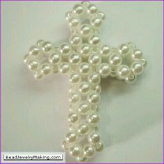 a cross made out of pearls on a white surface