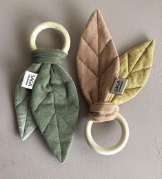 two green and brown leaf shaped teethpicks with tags on them sitting next to each other