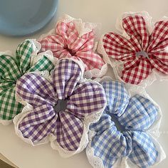 four different colored flowers are on the table