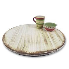 a wooden tray with two cups on it and a saucer next to it,