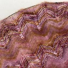 a close up view of a pink and brown knitted piece of cloth with wavy lines