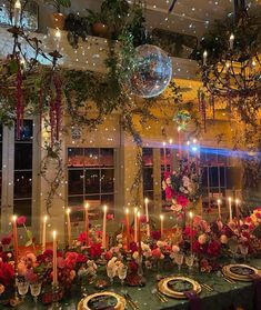 a table with candles, plates and flowers on it