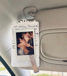 a photo hanging on the back seat of a car with a note attached to it