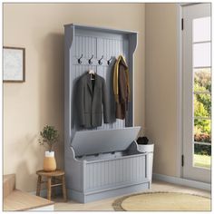 a coat rack with two coats hanging from it's sides and an open door