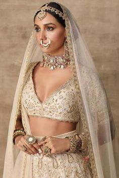 a woman wearing a bridal outfit and jewelry