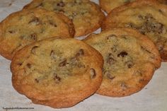 chocolate chip cookies sitting on top of a piece of parchment paper