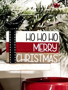 a red mug sitting next to a christmas sign