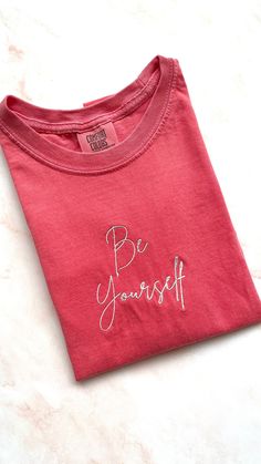 Embroidered pink colored t-shirt with phrase "Be Yourself" in white Each item is made to order so slight variations may occur Pink T Shirt, Pink Tshirt, Be Yourself, Comfort Colors, Sweat Shirt, Gender Neutral, Bathing Beauties, Adult Outfits, Sweatshirts Hoodie