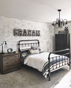 a bed room with a neatly made bed and a wooden dresser next to a brick wall