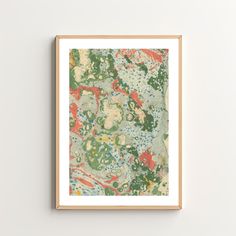 an abstract painting with green, red and blue colors on white paper in a wooden frame