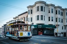 a trolley car is traveling down the street in front of a building with many windows