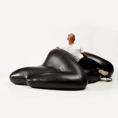 a man sitting on top of a black bean bag chair