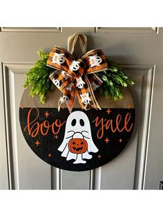 a halloween door hanger with a ghost and pumpkin on it