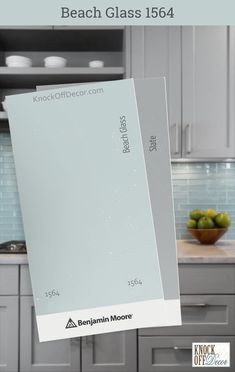 a kitchen with white cabinets and gray counter tops, has a glass door on the front