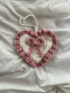 a crocheted heart hanging on a bed