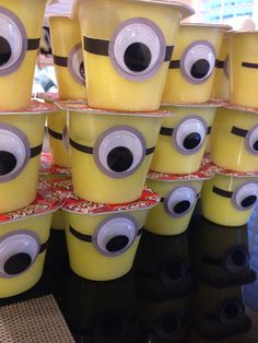 many yellow cups with eyes are stacked on top of each other in the shape of minion faces