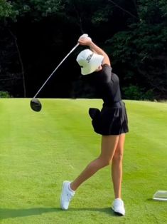 a woman hitting a golf ball on the green