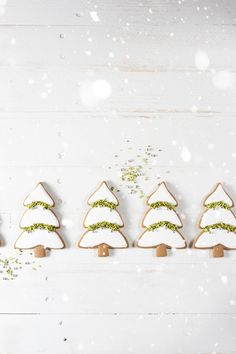 christmas cookies decorated with green sprigs are lined up in the shape of trees