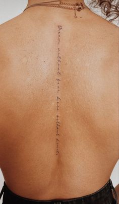 the back of a woman's neck with writing on her left shoulder and lower back