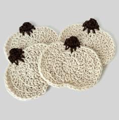 three crocheted coasters with black bows on them are sitting on a gray surface