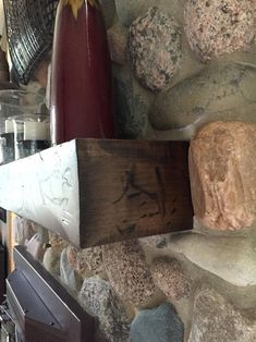 a stone wall with a wooden shelf and vases on it