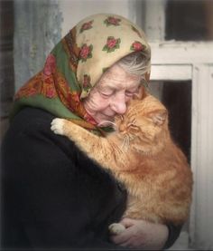 an old woman holding a cat in her arms