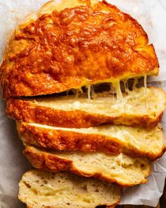 sliced bread with cheese on it sitting on wax paper