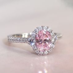 Jess spends her summers at her little white cottage in the English countryside. She throws enchanting garden parties... the sweet fragrance of pink roses filling the night air with romantic possibilities. Bess loves romantic movies, shopping in the village for antiques and feminine vintage-style rings. The Platinum Plated Sterling Silver Ring 1.2 carat Oval Pink CZ Stone Halo Ladies Engagement Ring (Size 5 to 9) is nothing short of breathtaking. With its vintage-style vibe, it showcases an eye-c Silver And Pink Wedding Ring, Light Pink Ring, Pink Wedding Rings Diamond, Pink Sterling Silver Ring, Pink Engagement Ring Vintage, Pink Promise Rings, Pink Rings Engagement, Pink Promise Ring, Engagement Rings Pink