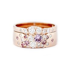 two wedding bands with pink and white diamonds on them, set in 18k rose gold