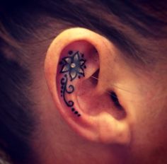 a woman's ear with a tattoo on it