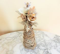 a vase filled with flowers sitting on top of a marble table covered in gold foil