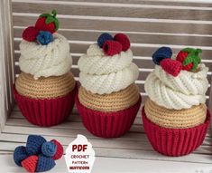 three crocheted cupcakes with strawberries on top are sitting next to each other