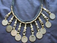 This is an unsigned choker or necklace with coin type embellishments. Most of them look more silver or pewter tone but a few look rather brassy. Closes via a button on the back. This measures about 16.25 inches long, so your neck would need to be smaller to wear this as a choker. Very primitive tribal boho looking. More vintage jewelry here: https://www.etsy.com/shop/badkittyvintagefinds?ref=hdr_shop_menu§ion_id=14398871 Bohemian Coin Necklace, Bohemian Silver Coin Necklace, Bohemian Metal Coin Necklace, Bohemian Festival Coin Necklace, Afghani Jwellary, Bohemian Coin-shaped Metal Necklace, Coin Choker, Ethnic Style, Coin Necklace