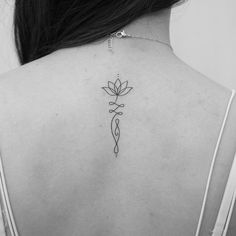 the back of a woman's neck with a tattoo on it