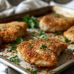 several pieces of chicken on a tray with parsley sprinkled around it and seasoning